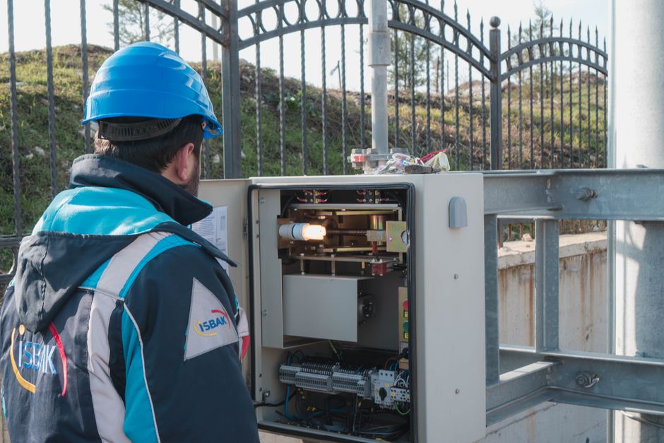 Elektriker med hjälm som kontrollerar ett elskåp utomhus