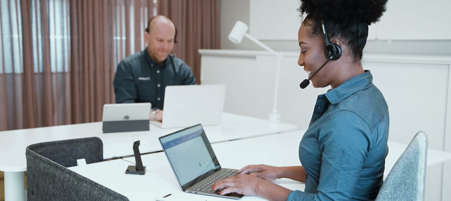 Supporttekniker med headset på Tacertos helpdesk hjälper kunder på distans