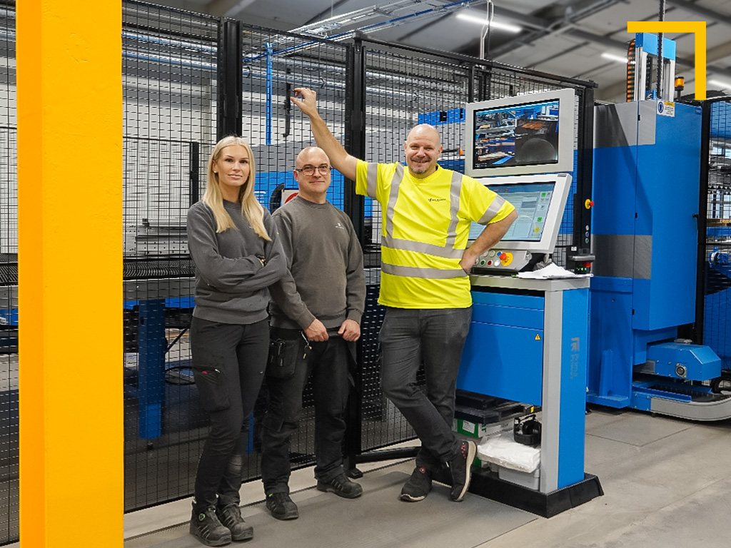 Tre medarbetare vid en nyinstallerad maskin i Hellbergs fabrik i Mellerud